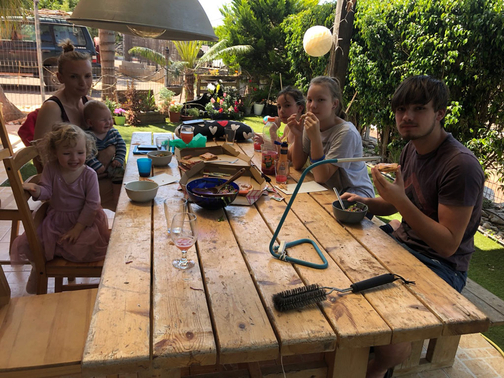 Unsere Familie am Tisch auf der Terrasse.